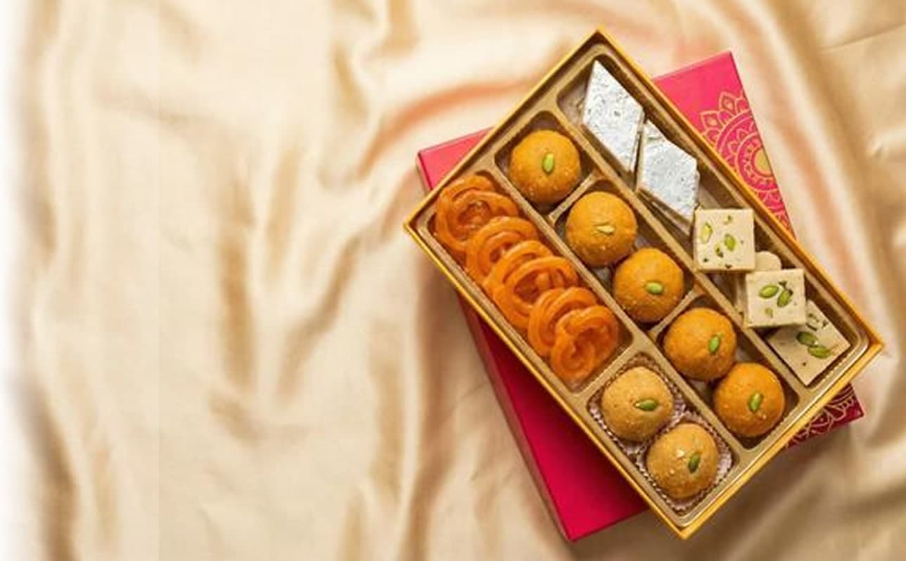Premium printed sweet box filled with jalebi, laddu and kaju katli on satin cloth